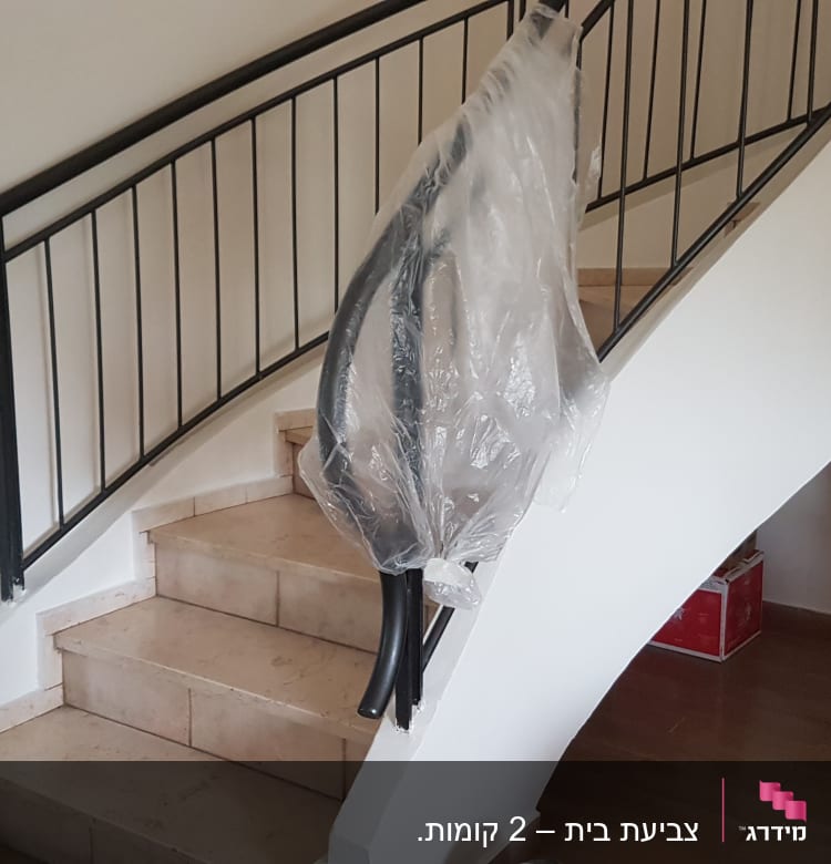 מעקה מדרגות מכוסה בניילון לקראת צביעה